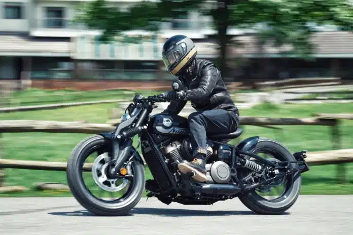 Benda Napoleon Bob 125 circulando en entorno urbano con piloto equipado y postura de conducción relajada.