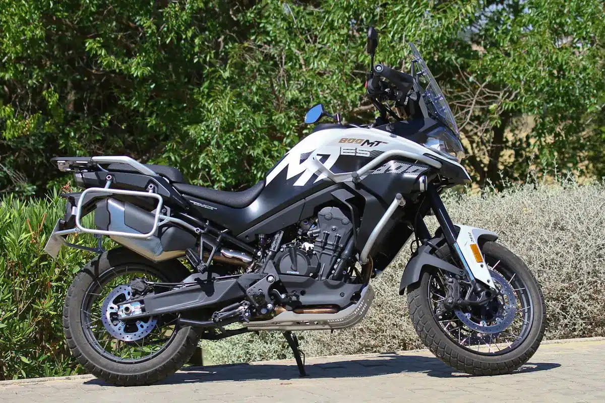 CFMOTO 800MT-ES vista de perfil, con llantas de radios, defensas, pantalla alta y herrajes para maletas.