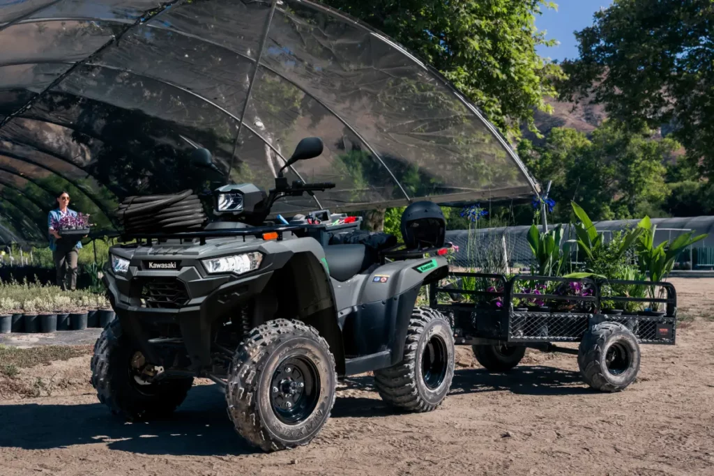 Los Kawasaki Brute Force 300 y 450 amplían su terreno de juego en 2027 con homologación T-Cat 3 Kawasaki Brute Force 300 2027 con remolque cargado junto a una zona de cultivo